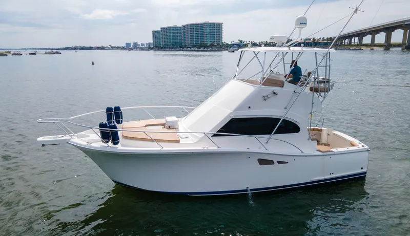 Slide: The Image of 2008 Luhrs 35 Convertible yacht on calm water, with cityscape and bridge in background. - 17