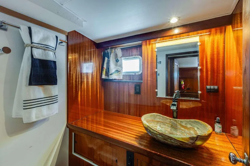 Slide: The Image of Luxurious bathroom on 1973 Hatteras 58 Tricabin yacht with elegant wood finish and vessel sink. - 13