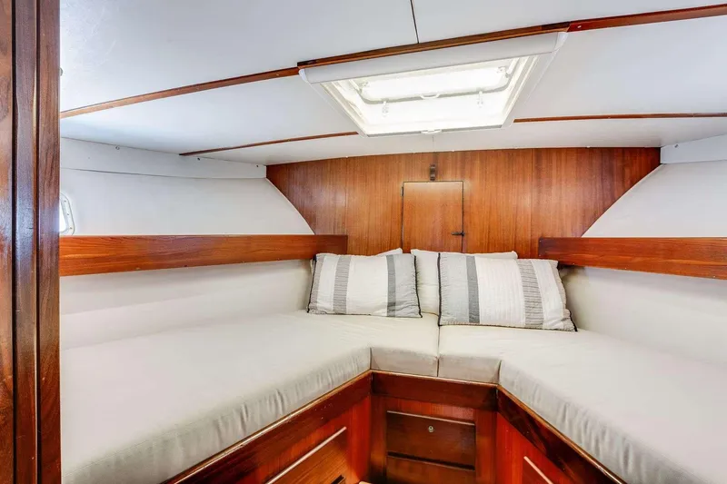 Slide: The Image of 1973 Hatteras 58 Tricabin flushdeck MY interior cabin with cozy bedding and wood paneling. - 15