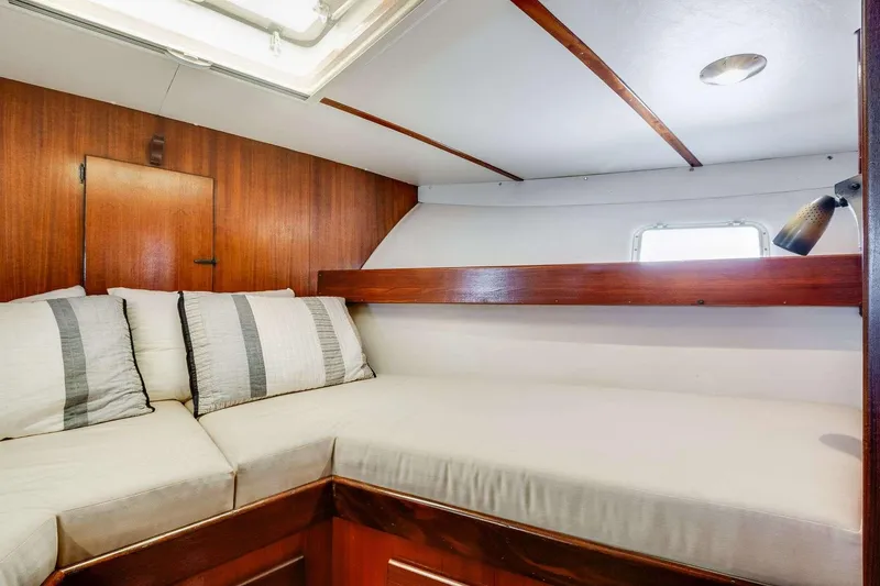 Slide: The Image of 1973 Hatteras 58 Tricabin flushdeck MY interior cabin with cozy bedding and wooden accents. - 16