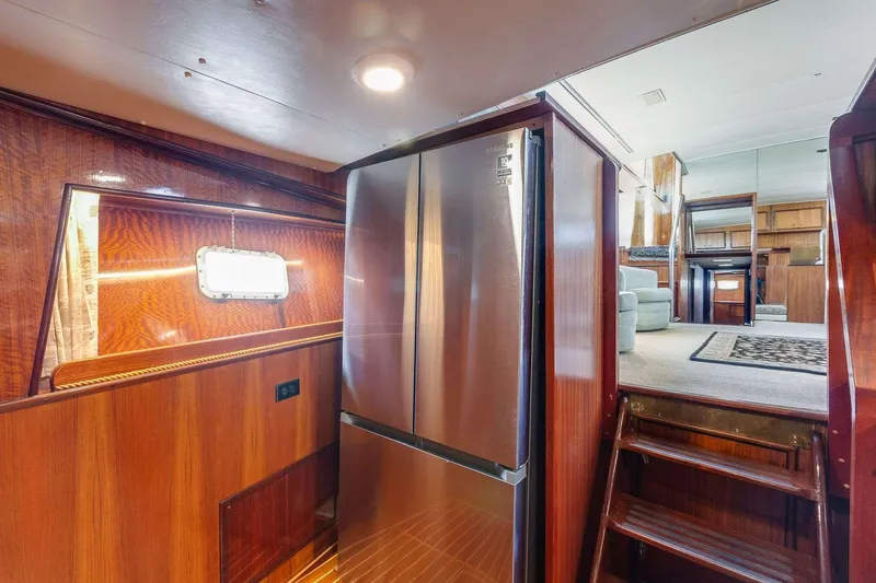 Slide: The Image of Interior of 1973 Hatteras 58 Tricabin yacht with stainless steel fridge and wooden finishes. - 18