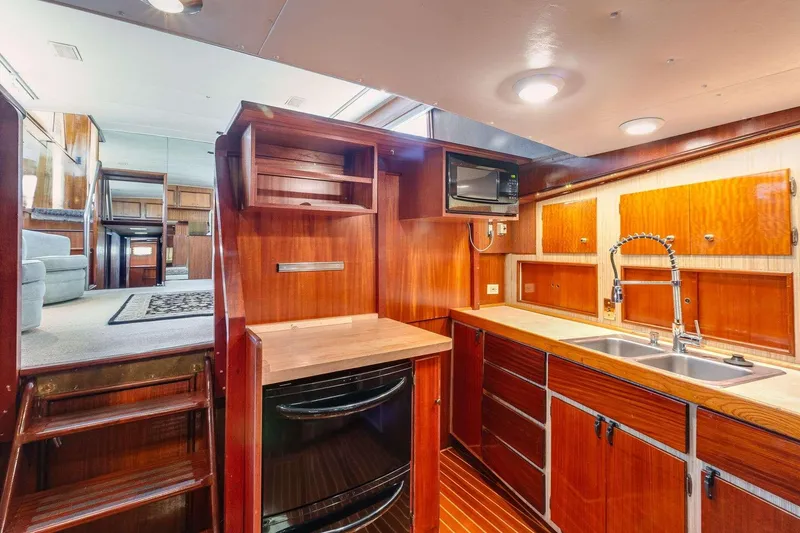 Slide: The Image of Interior of 1973 Hatteras 58 Tricabin flushdeck MY, featuring wood cabinetry and modern amenities. - 19