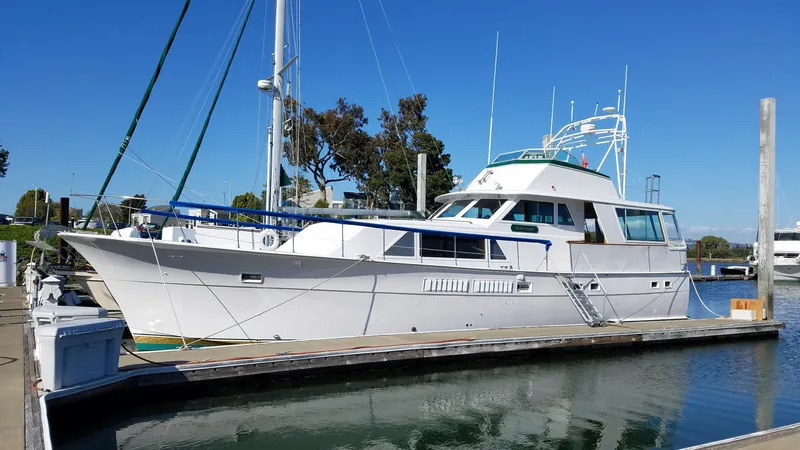 Slide: The Image of 1973 Hatteras 58 Tricabin flushdeck MY yacht docked at marina under clear blue sky. - 2