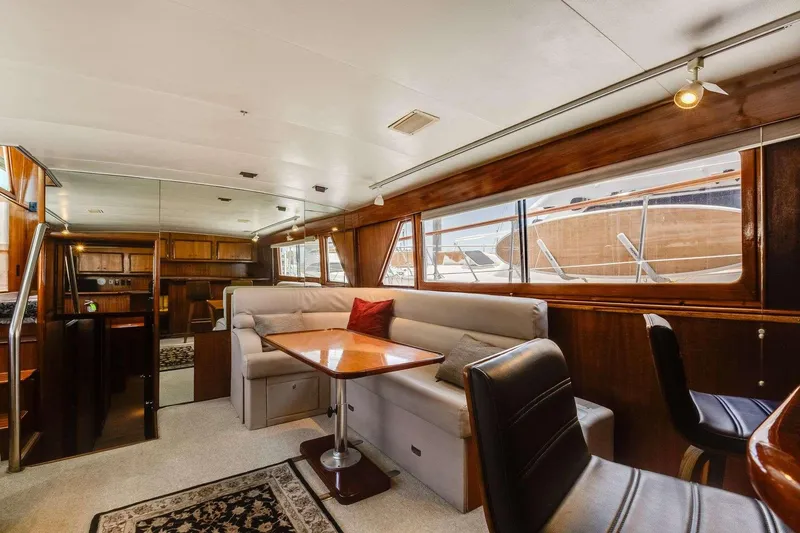 Slide: The Image of 1973 Hatteras 58 Tricabin yacht interior with dining area, plush seating, and wood accents. - 21
