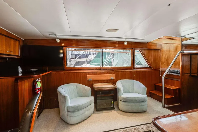 Slide: The Image of 1973 Hatteras 58 Tricabin yacht interior with plush seating and wooden accents. - 22
