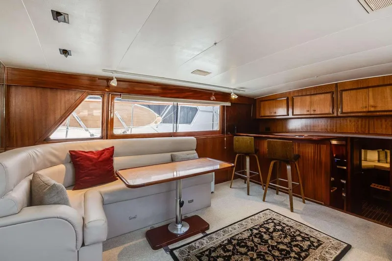 Slide: The Image of Interior of 1973 Hatteras 58 Tricabin yacht with elegant wood paneling and cozy seating area. - 26