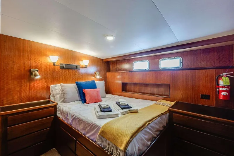Slide: The Image of Luxurious cabin interior of 1973 Hatteras 58 Tricabin yacht with cozy bedding and wooden finish. - 28