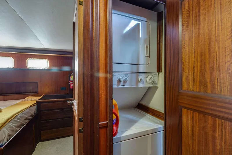 Slide: The Image of 1973 Hatteras 58 Tricabin yacht interior with washer-dryer unit and wooden cabinetry. - 37