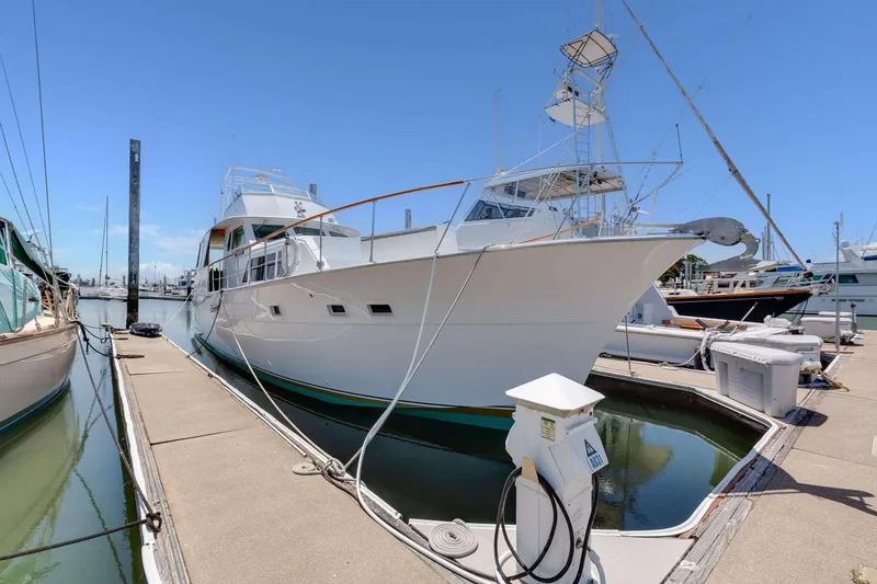 Slide: The Image of 1973 Hatteras 58 Tricabin flushdeck MY docked at marina under clear blue sky. - 4