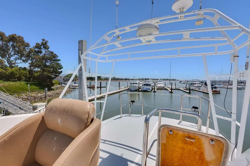 Slide: The Image of 1973 Hatteras 58 Tricabin flushdeck MY, docked with marina view, clear blue sky. - 42
