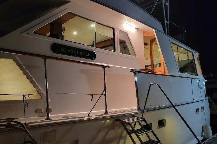 Slide: The Image of 1973 Hatteras 58 Tricabin flushdeck MY yacht, side view at night, named "Glass Eagle". - 44