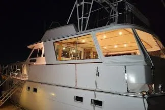 Slide: The Image of 1973 Hatteras 58 Tricabin flushdeck MY yacht illuminated at night. - 45