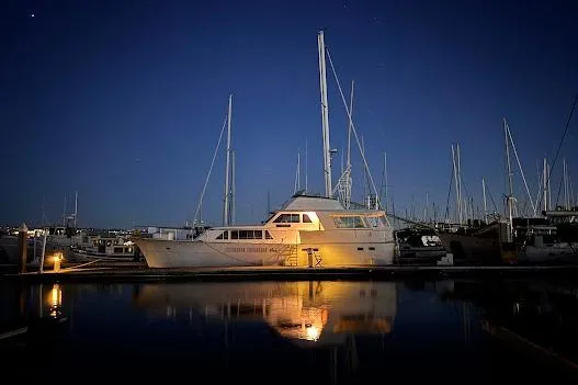 Slide: The Image of 1973 Hatteras 58 Tricabin yacht at night in harbor. - 46