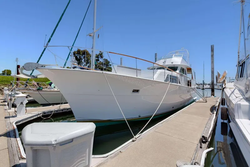 Slide: The Image of 1973 Hatteras 58 Tricabin flushdeck MY docked at marina under clear blue sky. - 5