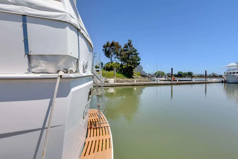 Slide: The Image of 1973 Hatteras 58 Tricabin flushdeck MY docked in a serene marina setting. - 8