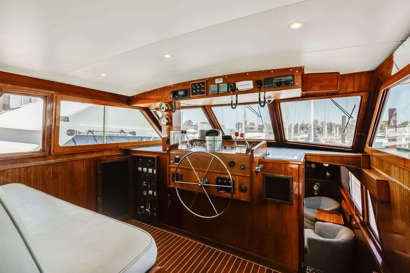 Slide: The Image of 1973 Hatteras 58 Tricabin flushdeck MY yacht interior with wooden helm and panoramic windows. - 9