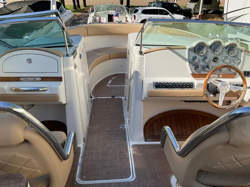Slide: The Image of 2014 Chris-Craft Launch 28 boat interior with beige seating and wooden steering wheel. - 4