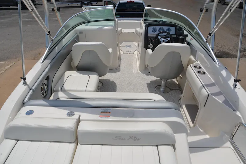 Slide: The Image of 2009 Sea Ray 210 Sundeck interior with white seating, steering wheel, and dashboard controls. - 18