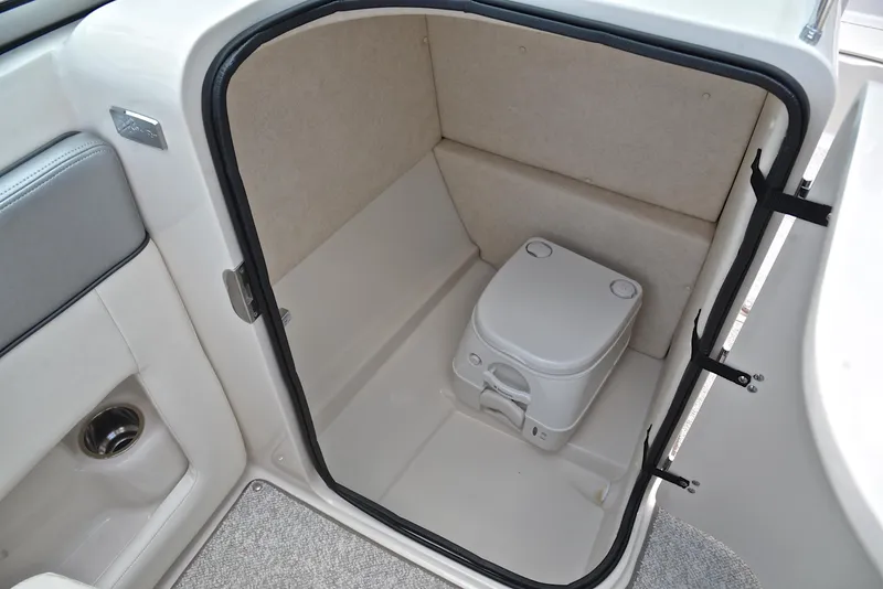 Slide: The Image of 2009 Sea Ray 210 Sundeck boat interior with compact portable toilet. - 27
