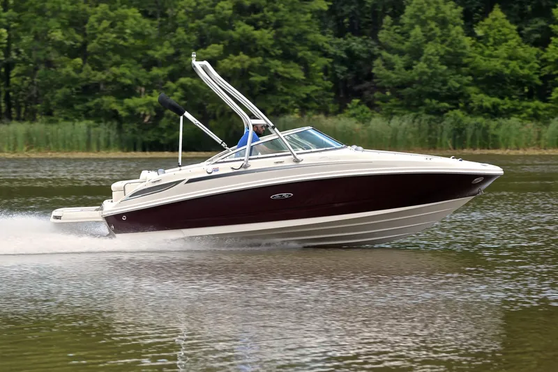 Slide: The Image of 2009 Sea Ray 210 Sundeck speeding on a lake with lush green trees in the background. - 3