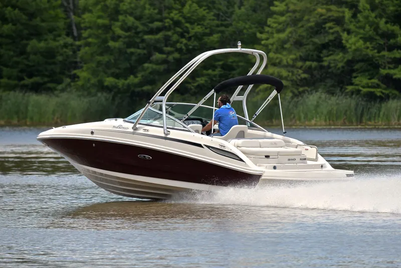 Slide: The Image of 2009 Sea Ray 210 Sundeck speeding on a lake with lush green trees in the background. - 4