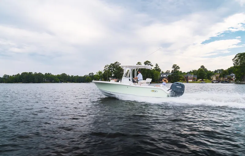 Slide: The Image of 2025 Sea Hunt Ultra 219 boat cruising on a scenic lake. - 13