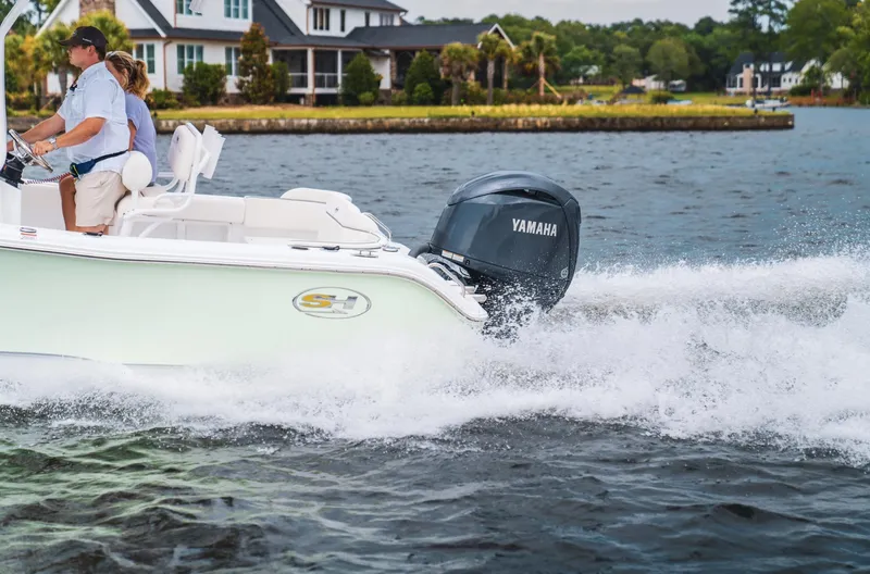 Slide: The Image of 2025 Sea Hunt Ultra 219 boat cruising on a lake with Yamaha engine. - 14