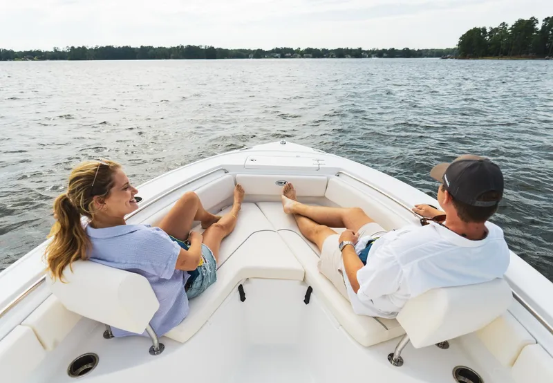 Slide: The Image of Couple relaxing on 2025 Sea Hunt Ultra 219 boat, enjoying a scenic lake view. - 19