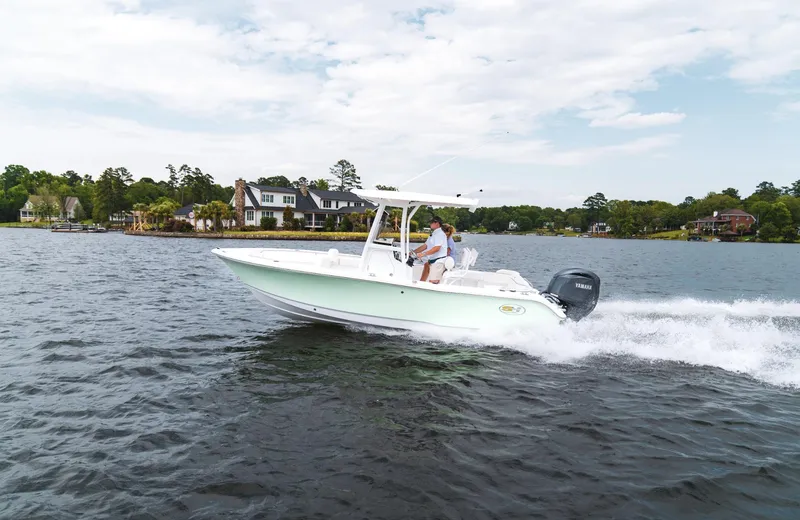 Slide: The Image of 2025 Sea Hunt Ultra 219 boat cruising on a scenic lake. - 23