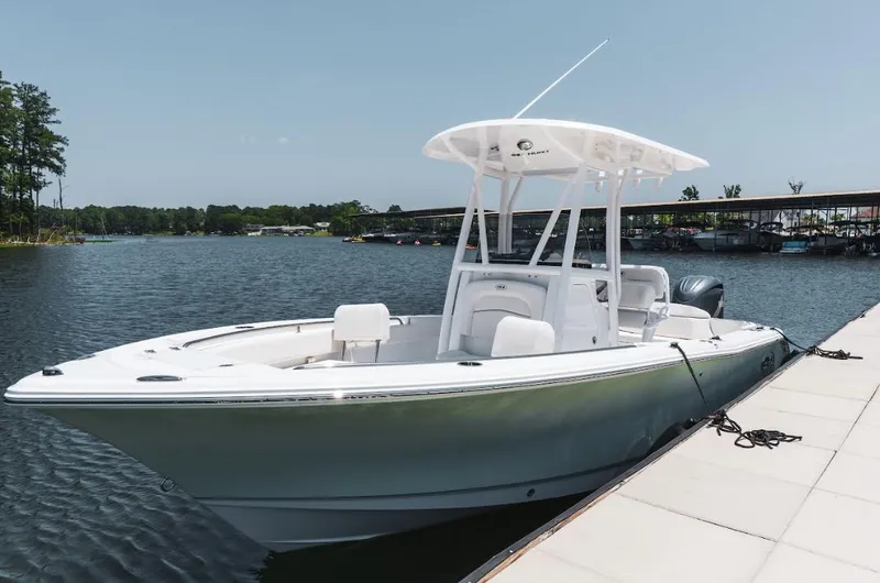 Slide: The Image of 2025 Sea Hunt Ultra 219 boat docked on a calm lake. - 4