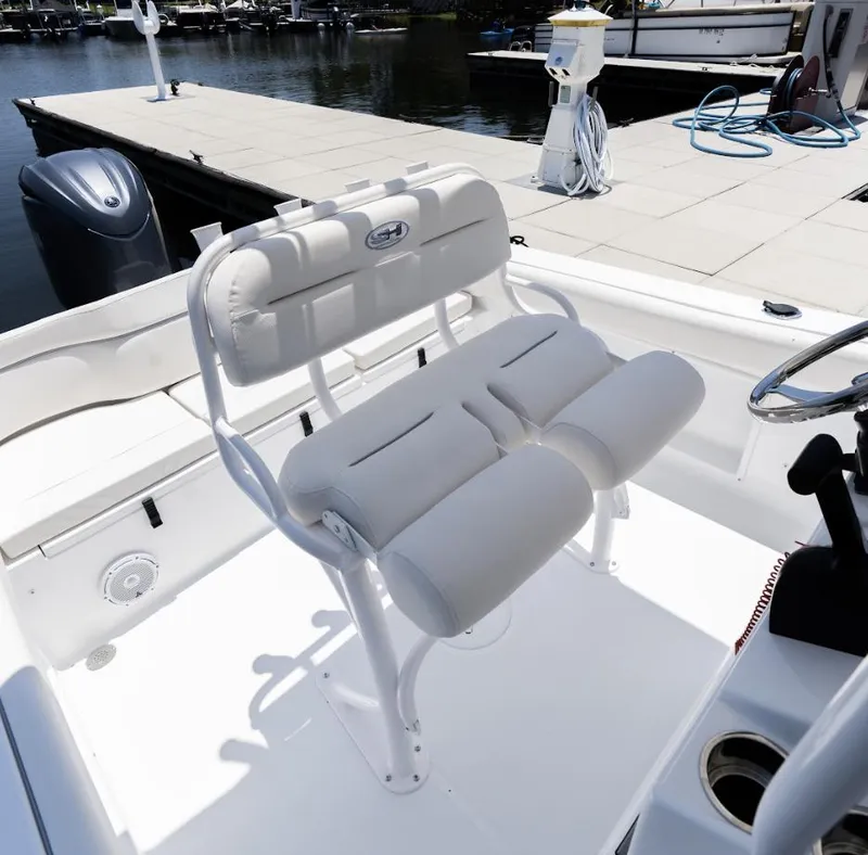 Slide: The Image of 2025 Sea Hunt Ultra 219 boat interior with cushioned seating at dock. - 5