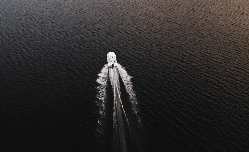 Slide: The Image of Aerial view of 2025 Sea Hunt Ultra 219 boat cruising on dark water. - 9