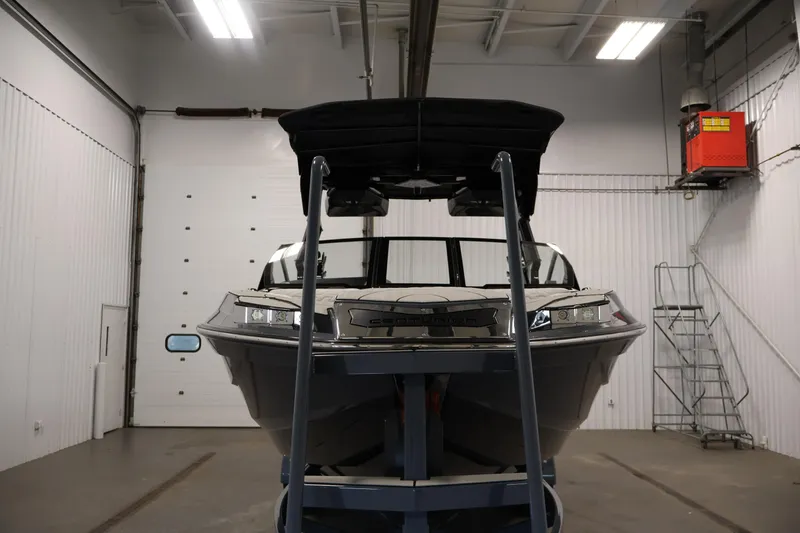 Slide: The Image of 2026 Centurion Ri245 boat in a garage, viewed from the front. - 1
