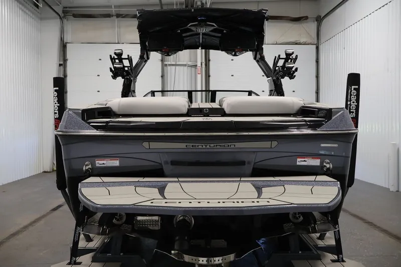 Slide: The Image of 2026 Centurion Ri245 boat in a garage, rear view showcasing sleek design. - 4