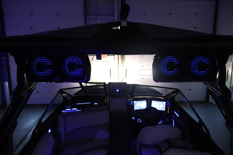 Slide: The Image of Interior of 2026 Centurion Ri245 boat with illuminated dashboard and speakers. - 59