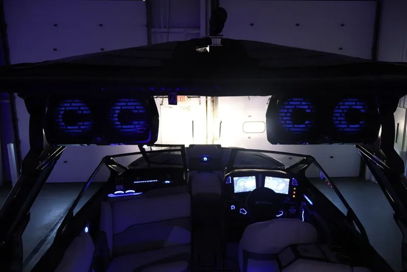 Slide: The Image of Interior of 2026 Centurion Ri245 boat with illuminated dashboard and speakers. - 58