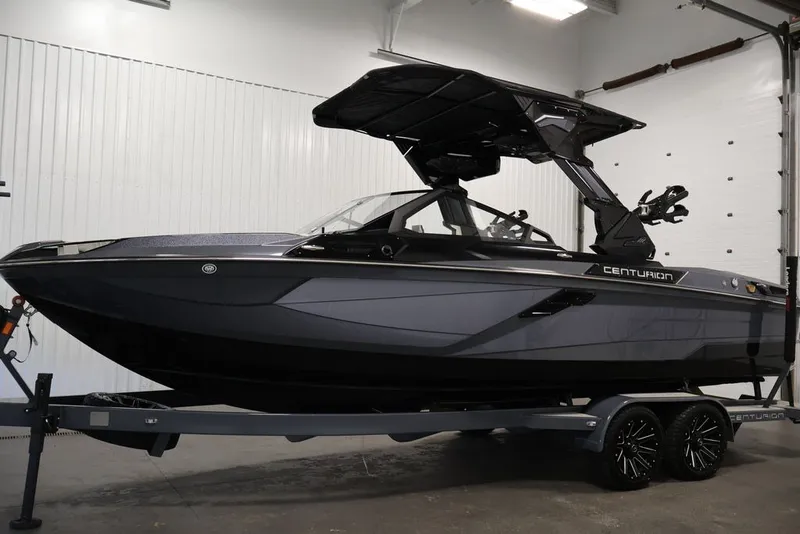 Slide: The Image of 2026 Centurion Ri245 boat in showroom, sleek design, black and gray color scheme. - 8