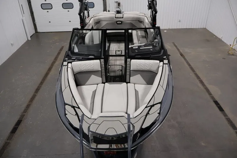 Slide: The Image of 2026 Centurion Ri245 boat interior with luxurious seating in a spacious garage. - 11
