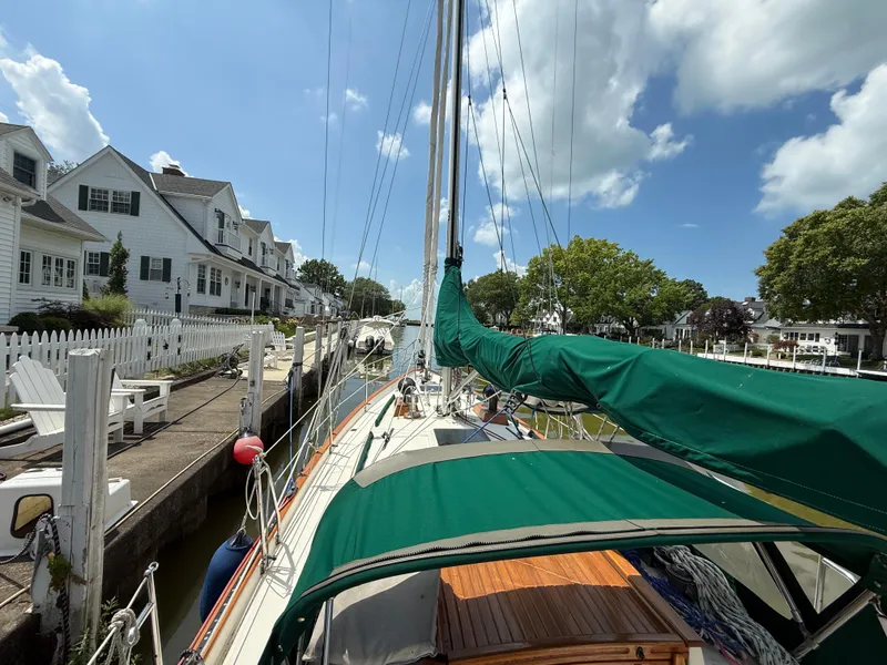 Slide: The Image of 1994 Pacific Seacraft 34 sailboat docked, featuring green canvas covers and Garmin equipment. - 10