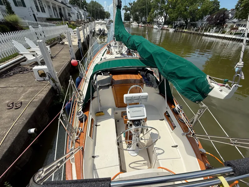 Slide: The Image of Sailboat docked in a scenic canal, Pacific Seacraft 34, 1994 model, with charming houses nearby. - 11