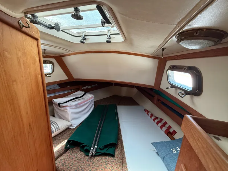 Slide: The Image of Interior cabin of 1994 Pacific Seacraft 34 sailboat with wooden finish and cozy sleeping area. - 17