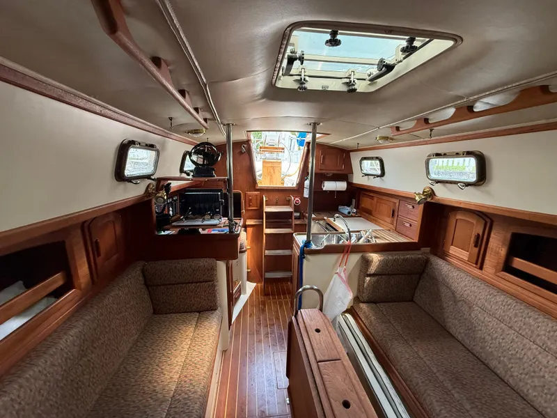 Slide: The Image of Interior of 1994 Pacific Seacraft 34 sailboat galley with wooden cabinetry and stainless steel sink. - 23