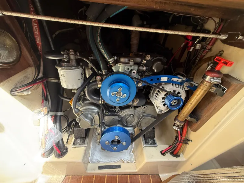 Slide: The Image of Engine compartment of a 1994 Pacific Seacraft 34 sailboat, featuring blue pulleys and wiring. - 25