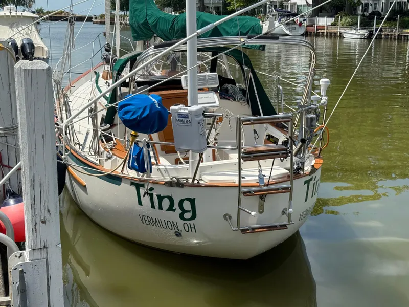 Slide: The Image of Sailboat docked, 1994 Pacific Seacraft 34, with green covers, in a serene marina setting. - 5