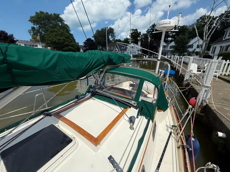 Slide: The Image of Sailboat docked in marina, Pacific Seacraft 34, 1994 model, with white deck and green accents. - 9