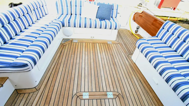 Slide: The Image of Luxury seating area on 2022 Hinckley Talaria 43 yacht with striped cushions and teak flooring. - 3