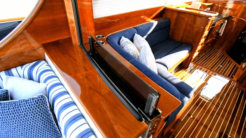 Slide: The Image of Luxurious interior of 2022 Hinckley Talaria 43 yacht with polished wood and blue seating. - 6