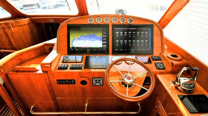 Slide: The Image of Helm of 2022 Hinckley Talaria 43 yacht with advanced navigation displays and wooden finish. - 9