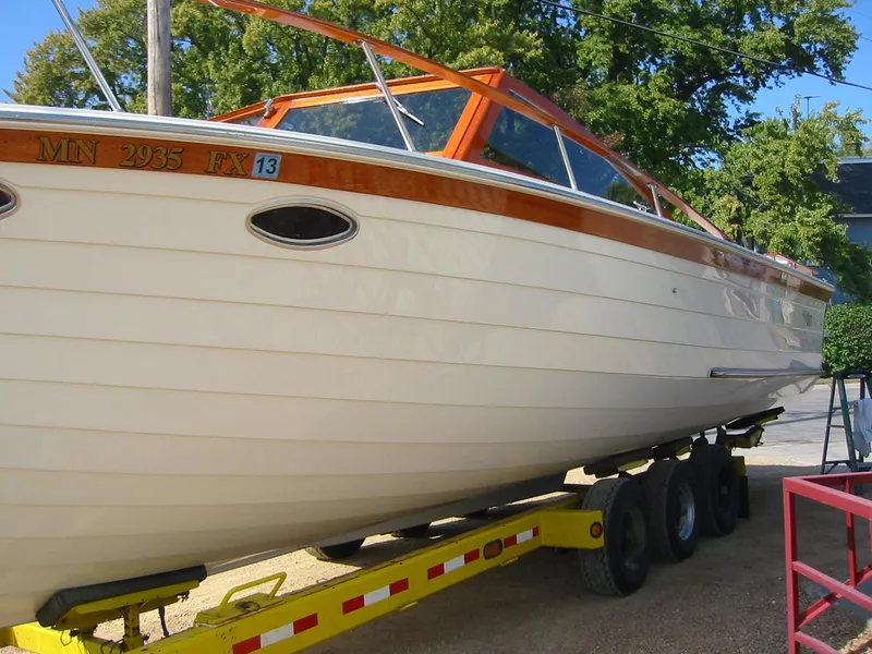 The Image of 1991 Windsor Craft 310 boat on trailer, showcasing sleek design and wood accents. - 1