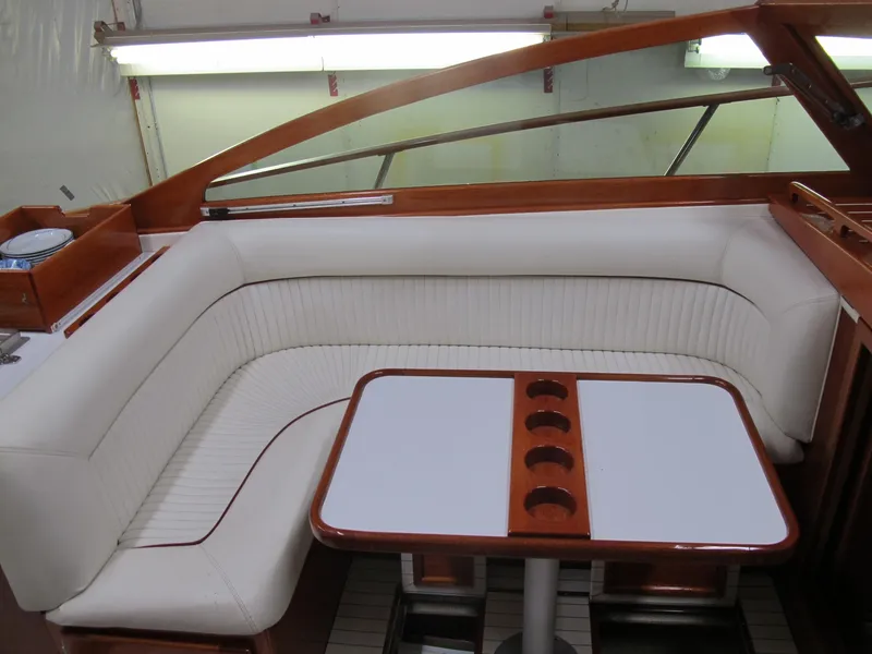 Slide: The Image of Luxurious interior of 1991 Windsor Craft 310 boat with white seating and wooden table. - 10